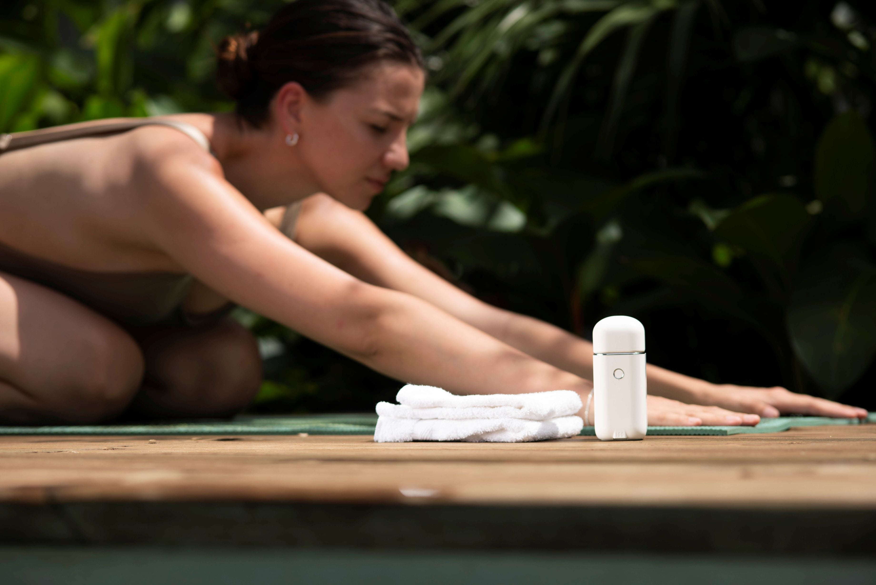 Woman in Yoga childs pose with i.D.O's air flow technology refillable antiperspirant deodorant 